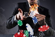 Ein Dealer der Jetons wirftt und brennende Karten hГ¤lt.